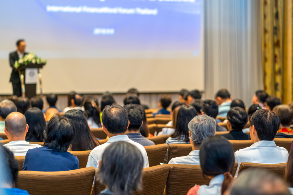 public écoutant un maître de conférence
